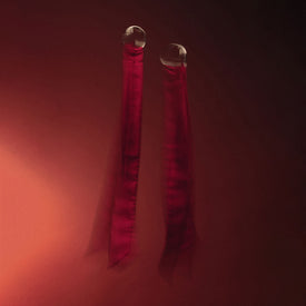 Les menottes en soie teinte rouge cerise et le chocolat cru Carrés Sauvages aux noisettes, Douceur