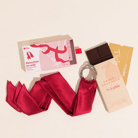 Les menottes en soie teinte rouge cerise et le chocolat cru Carrés Sauvages aux noisettes, Douceur